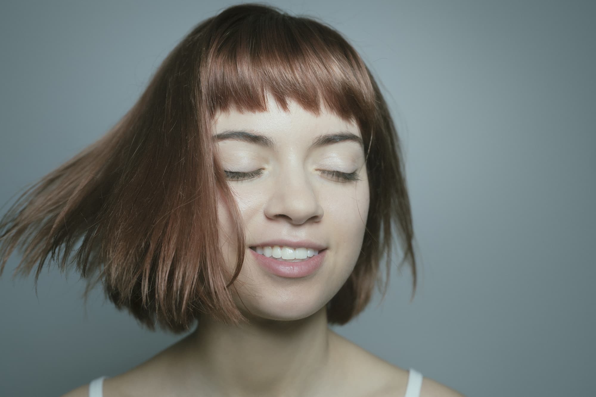 髪を振るボブヘアの女性