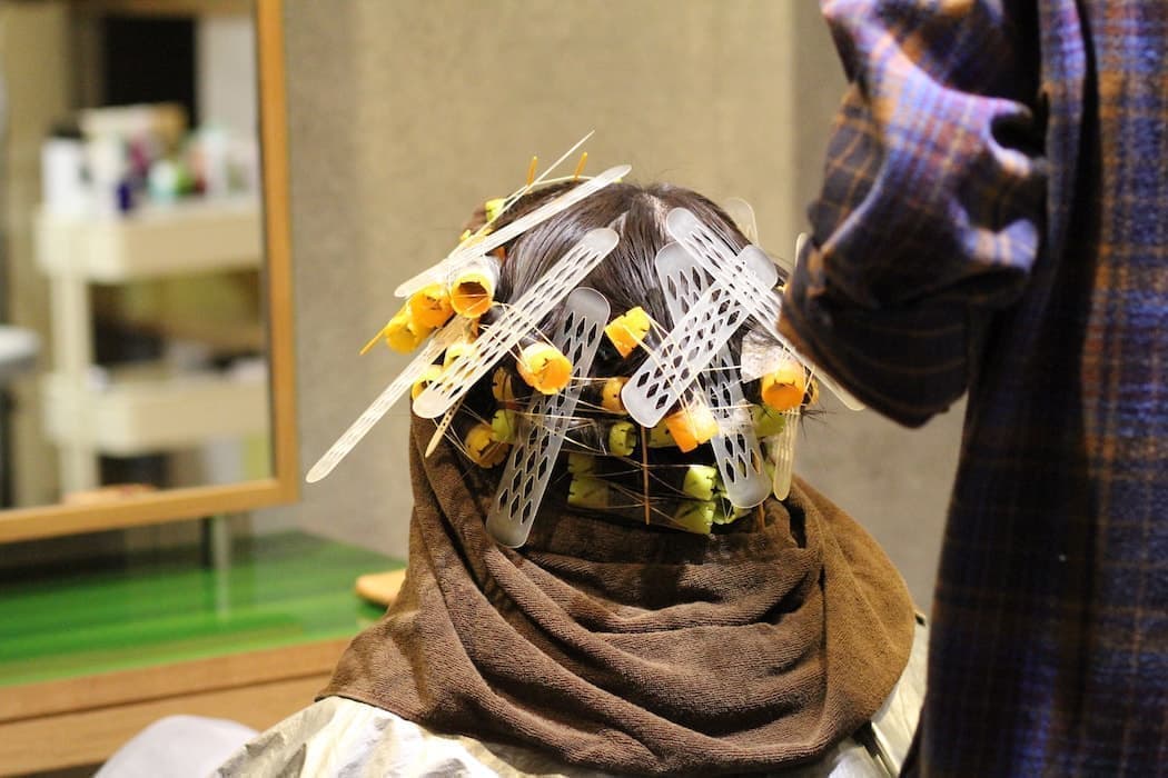 女性にパーマをかけている様子